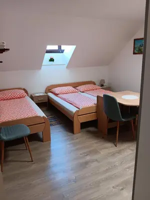 a bedroom with two beds and a table and chairs at turistična kmetija pr mark in Trebče