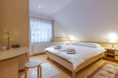 a bedroom with a bed and a desk and a window at Apartma Gaja in Kranjska Gora