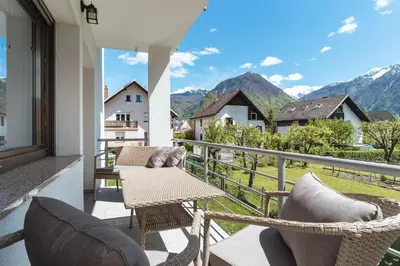 a balcony with chairs and a table and a view of mountains at Julian Manor apartments in Bovec