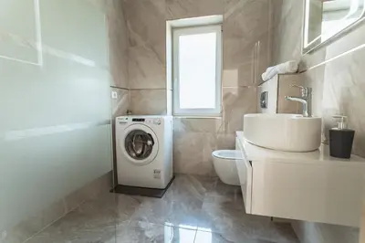a bathroom with a washing machine and a sink at Julian Manor apartments in Bovec