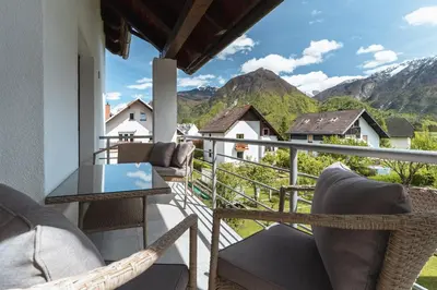 a balcony with chairs and a table and mountains at Julian Manor apartments in Bovec