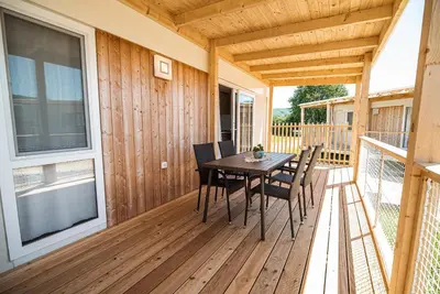 a wooden deck with a table and chairs on it at Mediteran Homes with Terme Čatež Tickets in Čatež ob Savi