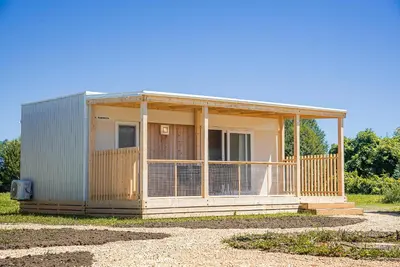 a small house with a large porch on a field at Mediteran Homes with Terme Čatež Tickets in Čatež ob Savi