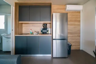 a stainless steel refrigerator in a small kitchen at Mediteran Homes with Terme Čatež Tickets in Čatež ob Savi