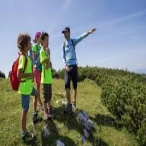 a group of people standing on a hill flying a kite at Hillside Bio Resort Apartment with Mountain View in Prebold