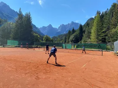 a group of people playing tennis on a tennis court at Hillside Bio Resort Apartment with Mountain View in Prebold