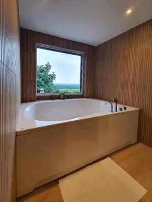 a large bath tub in a bathroom with a window at Počitniška hiša Grube z wellnesom in Puconci