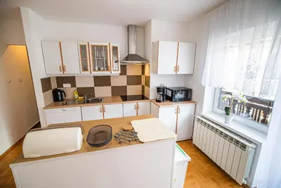 a kitchen with white cabinets and a wooden counter top at Vila K29 in Bovec
