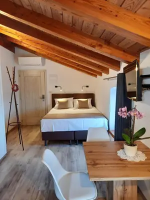 a bedroom with a bed and a table and chairs at Apartmaji in sobe Odlična hiša Štanjel in Štanjel