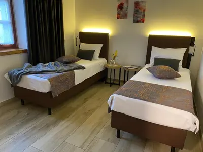 two beds in a hotel room with two at Apartmaji in sobe Odlična hiša Štanjel in Štanjel