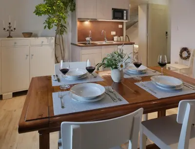 a wooden table with glasses of wine on it in a kitchen at Apartmaji in sobe Odlična hiša Štanjel in Štanjel