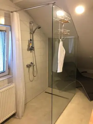 a shower with a glass door in a bathroom at Apartma na hüti in Radenci
