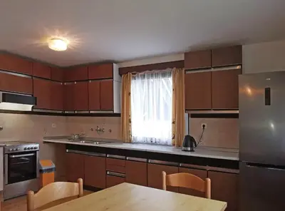 a kitchen with wooden cabinets and a table and a window at Apartment V&N, LAKE BOHINJ in Bohinj
