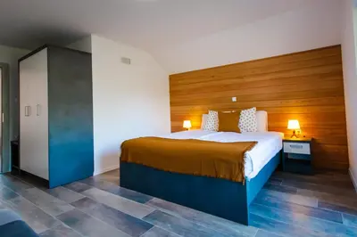 a bedroom with a large bed with a wooden headboard at Vineyard cottage Radulja in Smarjeske Toplice