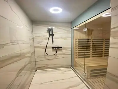 a bathroom with a shower with a phone on the wall at Vineyard cottage Radulja in Smarjeske Toplice