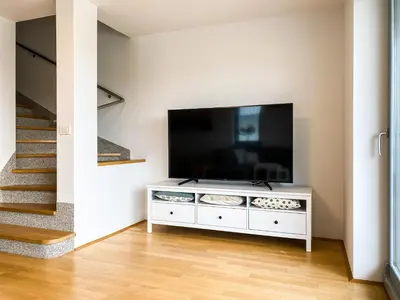 a living room with a flat screen tv on a white cabinet at Lakeview Villa Bled in Bled