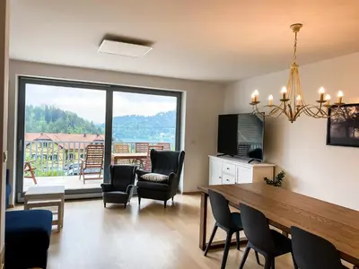 a living room with a table and chairs and a large window at Lakeview Villa Bled in Bled