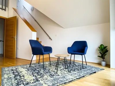 two blue chairs and a table in a room at Lakeview Villa Bled in Bled