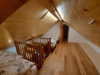 an attic room with two beds and a staircase at Oldhouse Knezovo in Sromlje