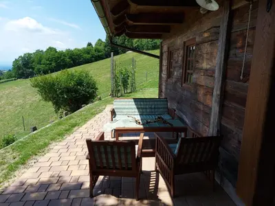 a patio with two chairs and a table on a building at Oldhouse Knezovo in Sromlje