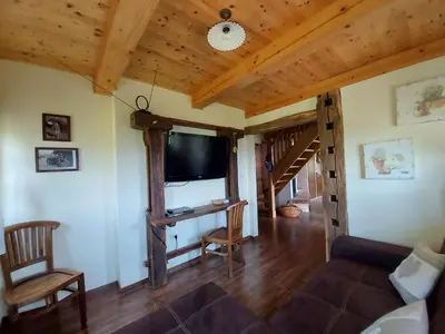 a living room with a large window and wooden ceilings at Oldhouse Knezovo in Sromlje