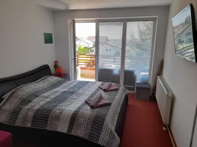 a bedroom with a bed with two slippers on it at Honey Apartment in Moravske Toplice