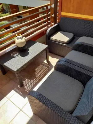 a patio with two chairs and a table with a bowl on it at Honey Apartment in Moravske Toplice