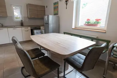 a kitchen with a wooden table and chairs at Sobe v Gozdu in Gozd Martuljek