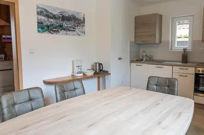 a kitchen with a wooden table and chairs at Sobe v Gozdu in Gozd Martuljek