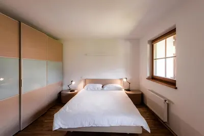 a bedroom with a large white bed and a window at Tromeja in Rateče