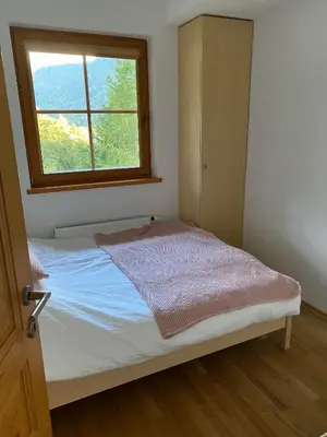 a small bedroom with a bed with a window at Tromeja in Rateče