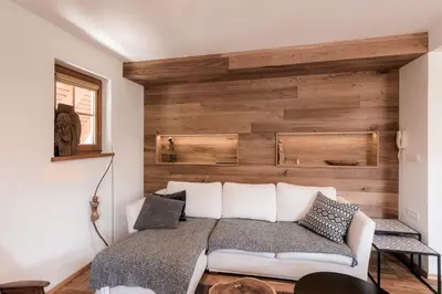 a bedroom with a bed with a wooden wall at Tromeja in Rateče
