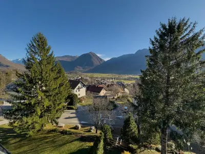a village with trees and mountains in the background at Cozy Apartment Bovec in Bovec