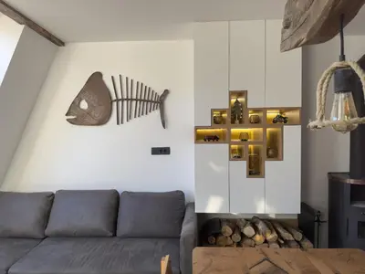 a living room with a couch and a fish on the wall at Cozy Apartment Bovec in Bovec