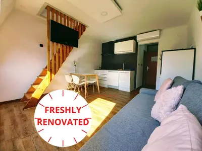 a living room with a couch and a kitchen at Cozy Apartment Bovec in Bovec