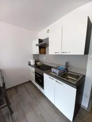 a small kitchen with white cabinets and a sink at Cozy Apartment Bovec in Bovec