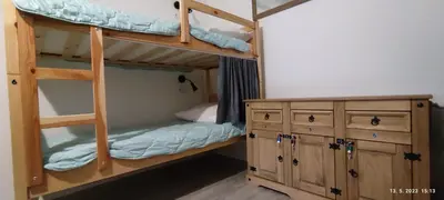 a bedroom with two bunk beds and a wooden cabinet at PRENOČIŠČE 9a in Tolmin