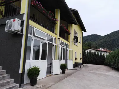 a yellow building with white doors and windows at PRENOČIŠČE 9a in Tolmin