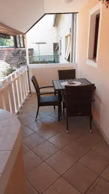 a patio with a table and chairs on a balcony at Apartma pri Gradu in Brežice