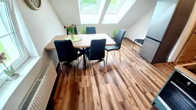 a kitchen with a table and chairs and a refrigerator at Apartma Rožle in Mojstrana