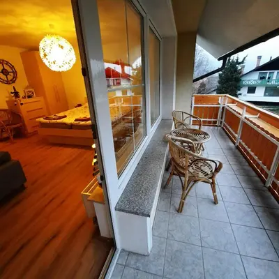 a balcony with two chairs and a bench and a bedroom at Apartma Rožle in Mojstrana