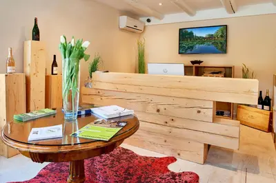 a living room with a table and a tv at Pikol Lake Village Wine Estate in Nova Gorica