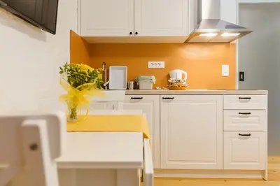 a kitchen with white cabinets and a vase of flowers at Frida's Old House in Bled
