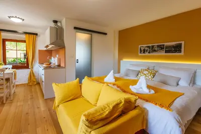 a bedroom with a large bed and a yellow couch at Frida's Old House in Bled