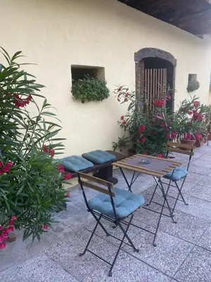 a patio with a table and chairs and flowers at Frida's Old House in Bled