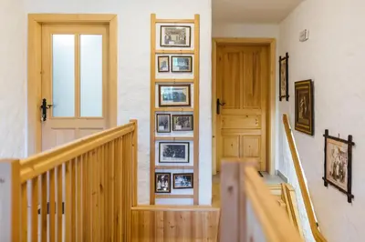 a hallway with a staircase with pictures on the wall at Frida's Old House in Bled