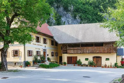 a large yellow building with a gray roof at Frida's Old House in Bled