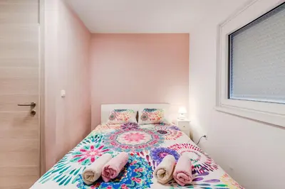 a small bedroom with a bed with slippers on it at Apartment Mojca in Bovec