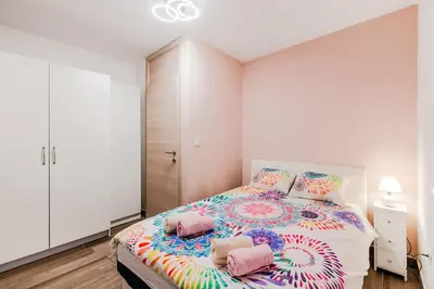 a bedroom with a large bed with colorful pillows at Apartment Mojca in Bovec