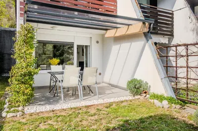 a patio with a table and chairs in a backyard at Apartment Mojca in Bovec
